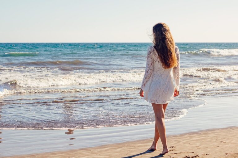 Person walking calmly on a beach at sunrise embracing peace and relaxation