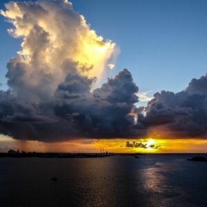 Sunset with dark storm clouds approaching, symbolizing strength and resilience through challenges