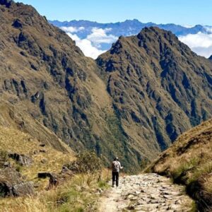 Person walking on a mountain path, representing vulnerability and emotional courage through hypnosis.