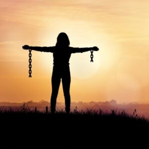 Person standing strong on a mountain, symbolizing mental freedom and taking your mind to the next level.