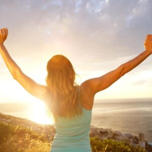 Woman raising her hand while walking uphill, symbolizing lifting depression and empowerment.