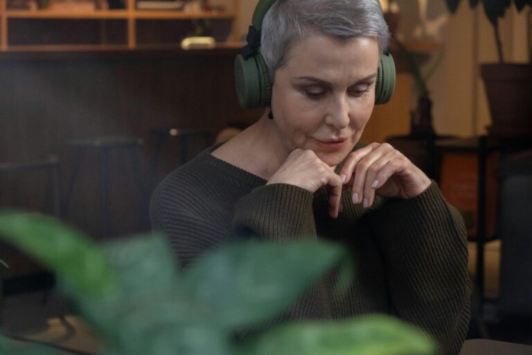 Woman wearing headphones, calmly listening to a hypnotherapy app designed to improve memory.