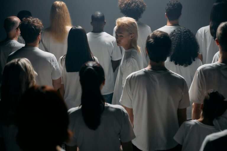 A diverse group of people standing together in soft light, symbolizing inclusivity, unity, and collective strength.