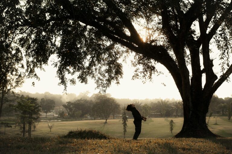 Man standing beside a tall tree, symbolizing roots of resilience and inner strength