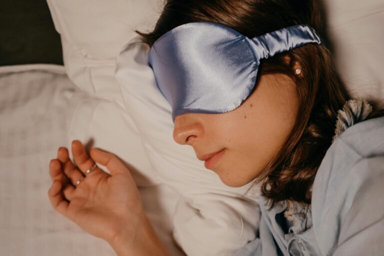 Person lying calmly in bed with eyes closed, appearing relaxed and at peace.