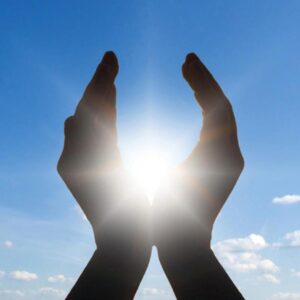 A close-up of a hand with the sun glowing at its center, symbolizing healing, energy, and the body’s natural power to restore balance.