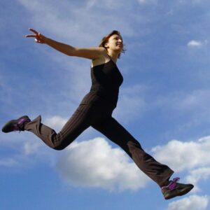 A person jumping high into the sky, symbolizing freedom, strength, and motivation.