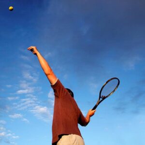 A focused tennis player holding a racket, ready to serve with confidence and precision.