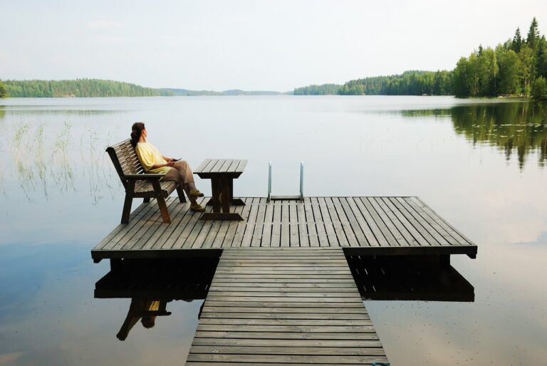 A man sitting quietly on a bench, reflecting in a calm and peaceful environment, symbolizing mindfulness and emotional rest.