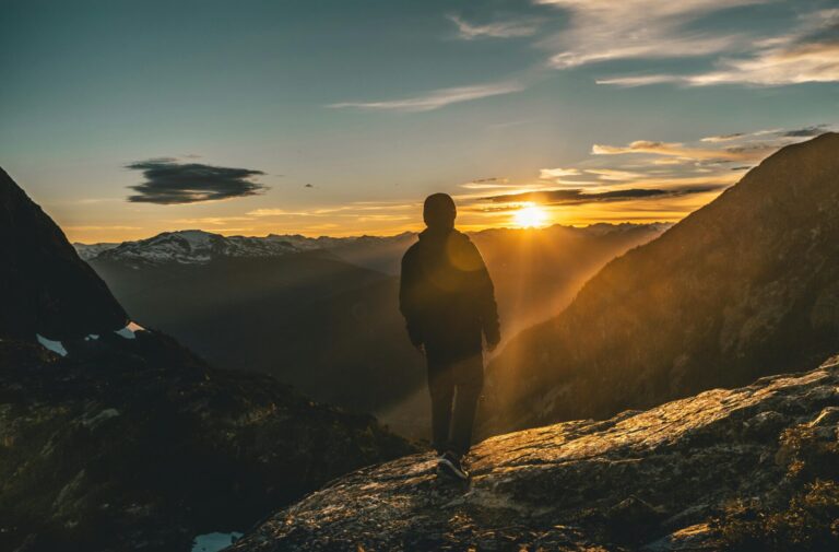 A person standing on the top of a hill, looking out at the horizon with calm confidence, symbolizing achievement, clarity, and inner strength.