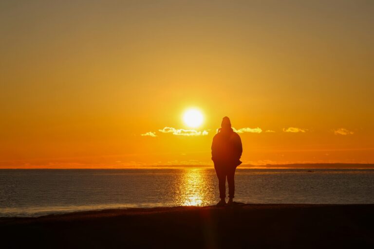 A person standing under a warm golden sunrise, symbolizing new beginnings, financial confidence, and a sense of renewal.