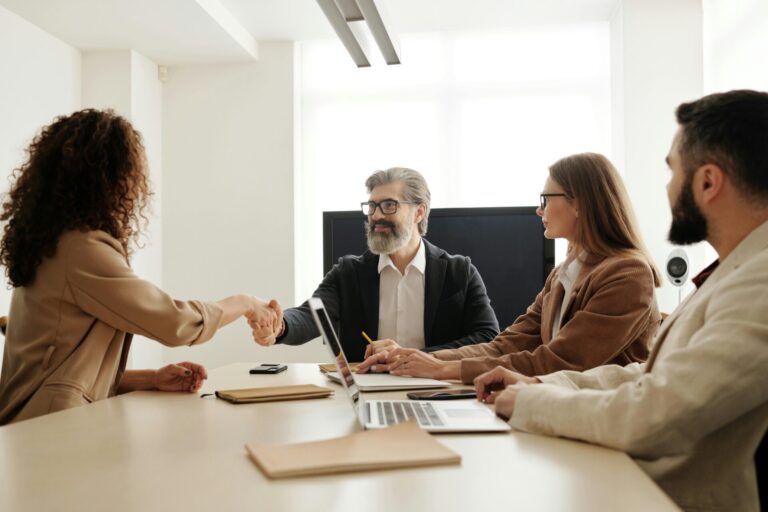 A joyful woman shaking hands after being accepted in a job interview, symbolizing confidence, achievement, and success through hypnotherapy.