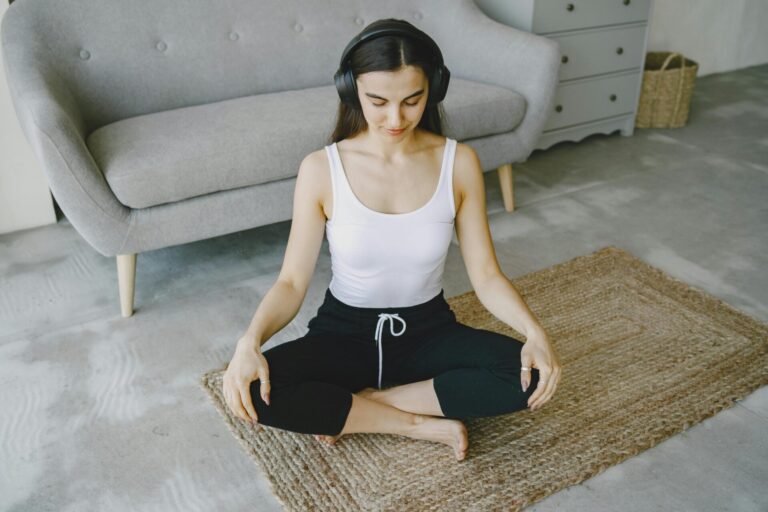 A person wearing headphones and meditating while using a phone, symbolizing relaxation, mindfulness, and guided meditation practice