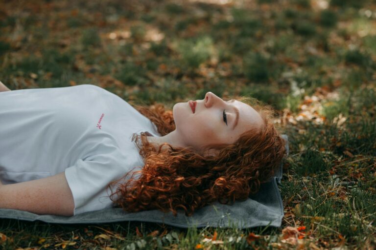 A person lying back peacefully with eyes closed, bathed in soft natural light