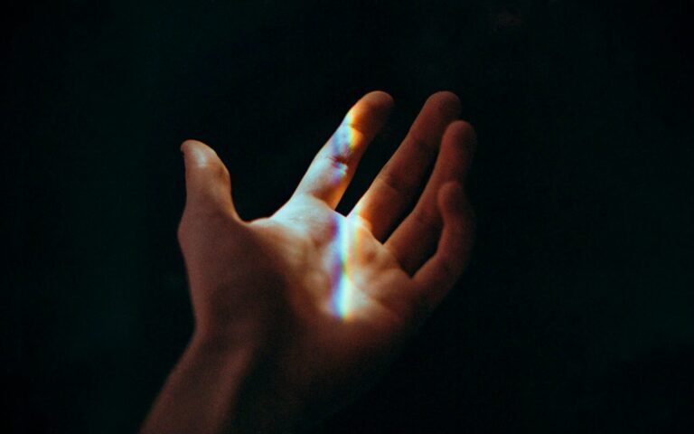 Open hands gently holding soft glowing light, symbolizing hope, healing, and positive energy.
