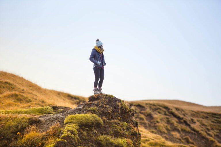 A person standing peacefully on a mountain ridge at sunrise, symbolizing strength, clarity, and emotional freedom through hypnotherapy for addiction recovery.