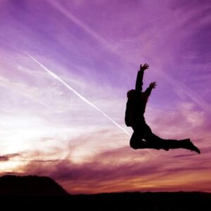 A person standing on an open landscape, arms wide, symbolizing the release of fear and embracing courage.