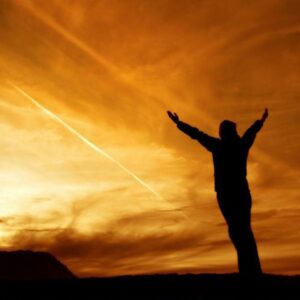 A person standing in a serene setting, gently letting go of emotional pain and hurt.