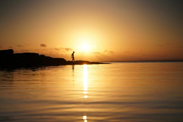 A person walking toward the sunrise, symbolizing hope, renewal, and personal growth.