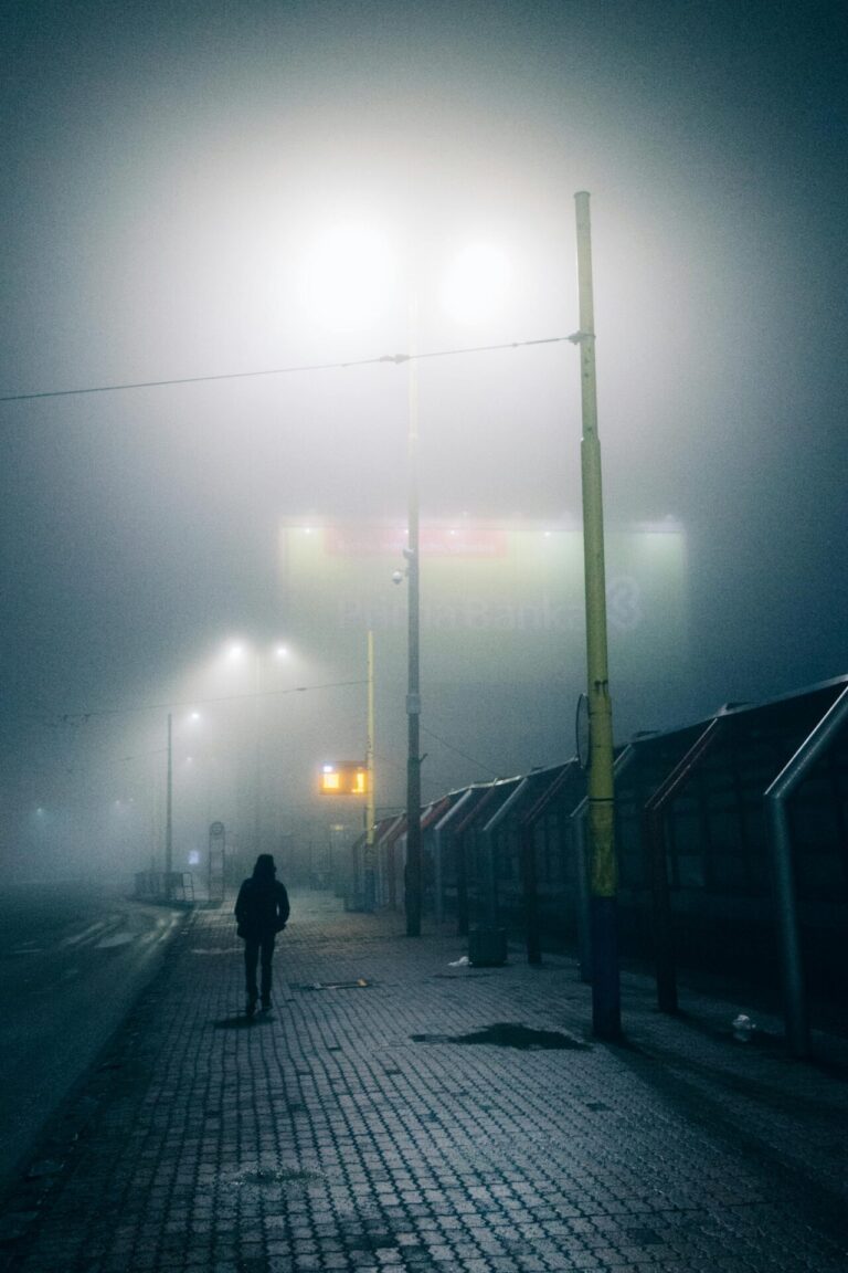 Lonely person walking alone at night, symbolizing emotional isolation and sadness