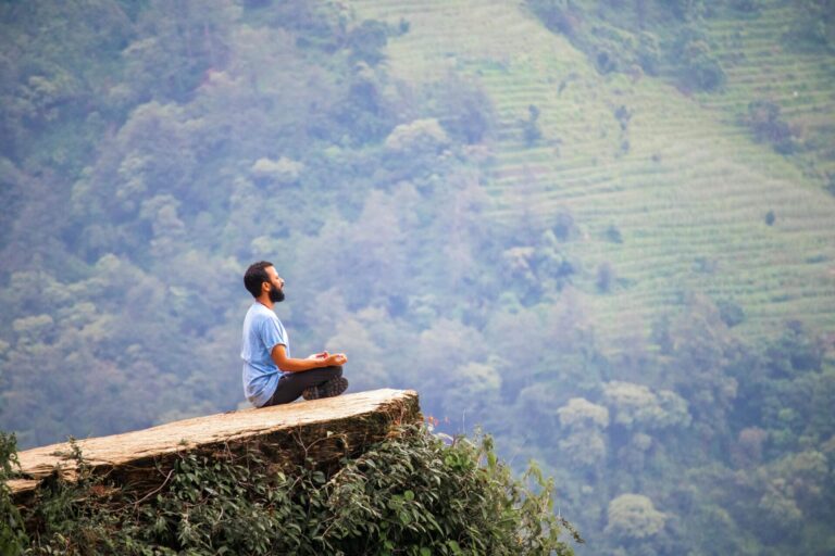 Person meditating peacefully outdoors in a natural setting
