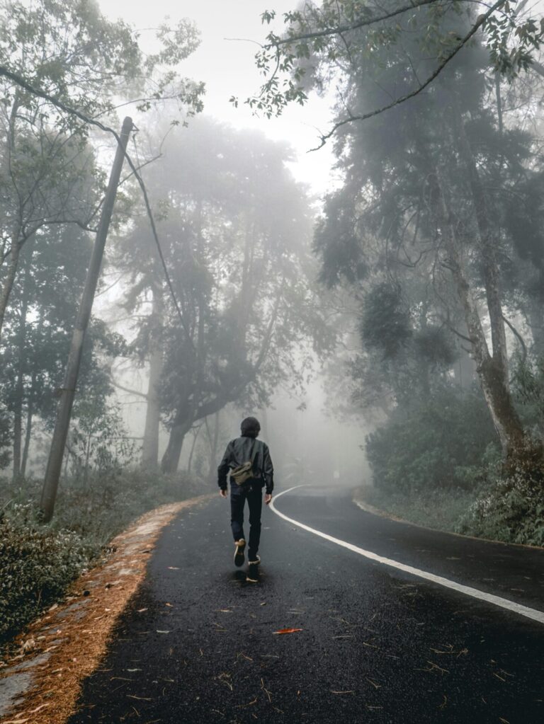 Person walking calmly along an empty road, symbolizing focus and journey