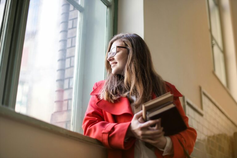 Student staring out the window while studying, appearing distracted and thoughtful
