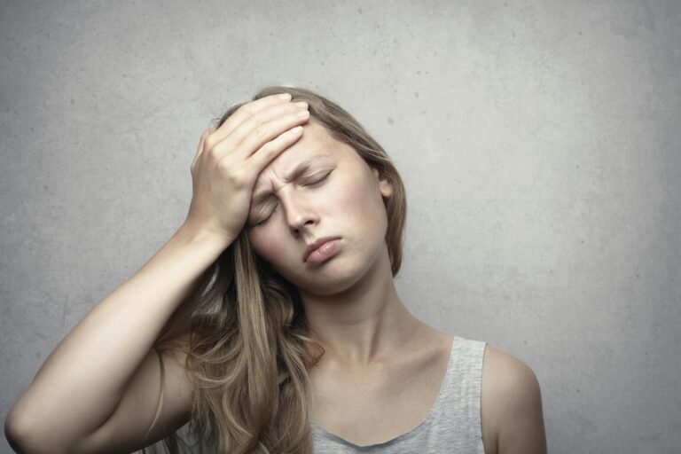 Woman holding her head in pain from a migraine