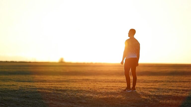 “Person standing tall in strong sunlight showing confidence and strength”