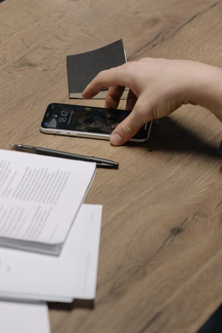 Person unconsciously reaching for their phone while surrounded by other tasks