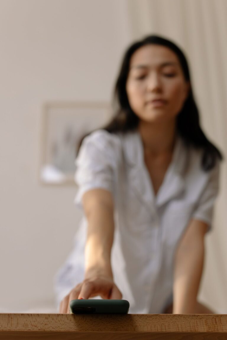 Person pausing before picking up their phone in a moment of awareness