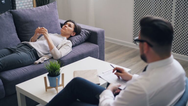 Person in a calm hypnotherapy session with eyes closed, showing relaxation and openness