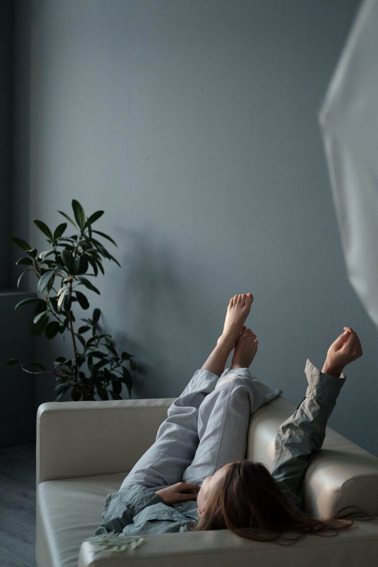 Person lying comfortably in a softly lit, cozy space during relaxation