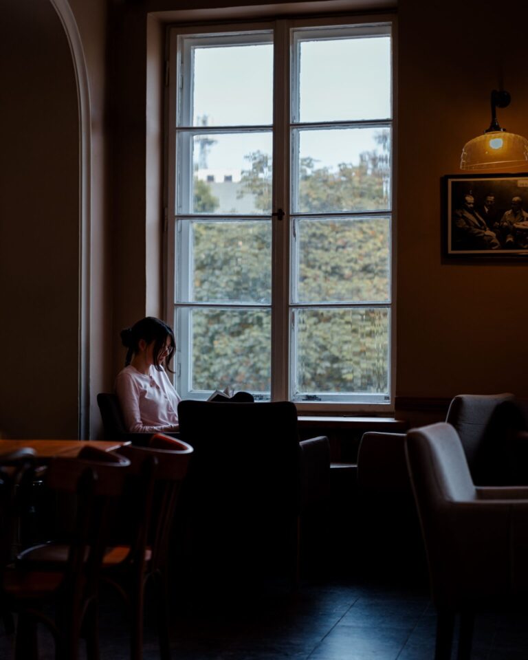 Person sitting indoors near a window with soft natural daylight