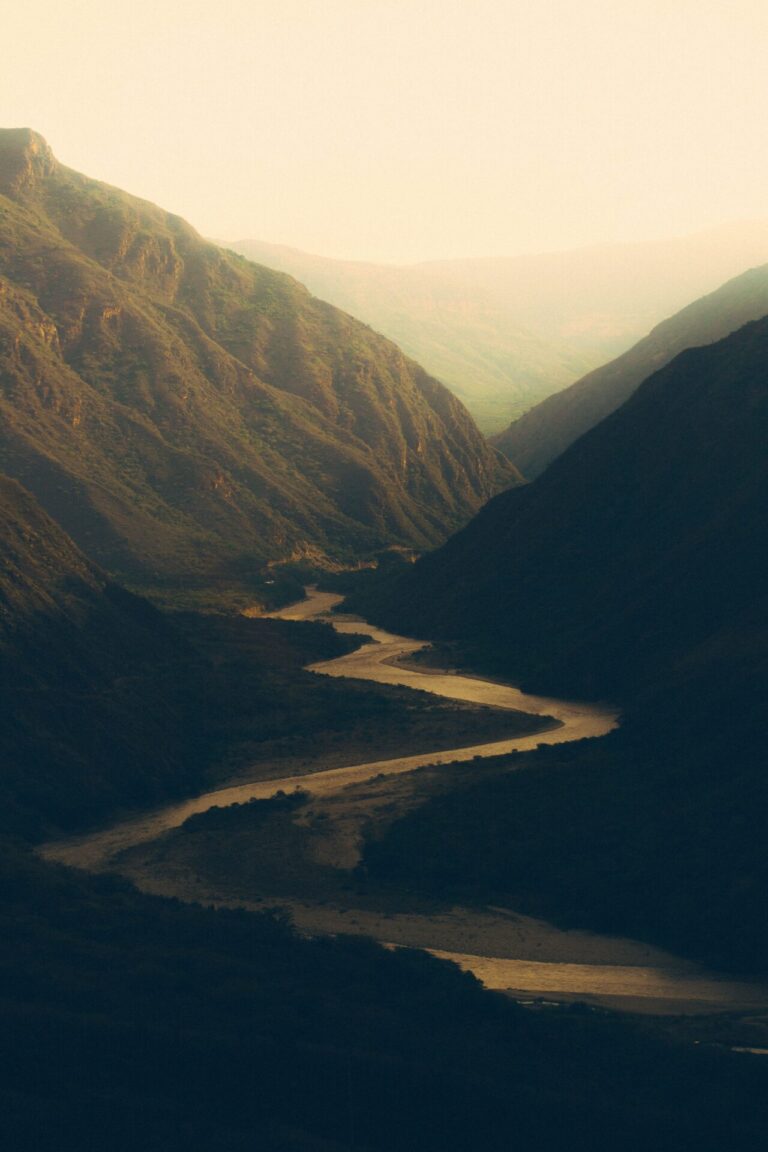 Serene winding mountain path at dusk surrounded by peaceful natural scenery